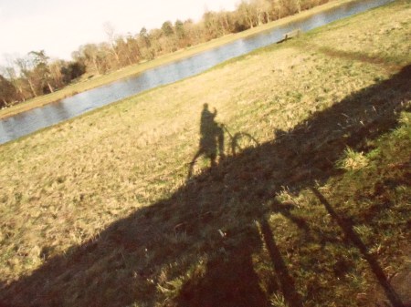 shadow of a bicycle with river in the background all at an agle upwards